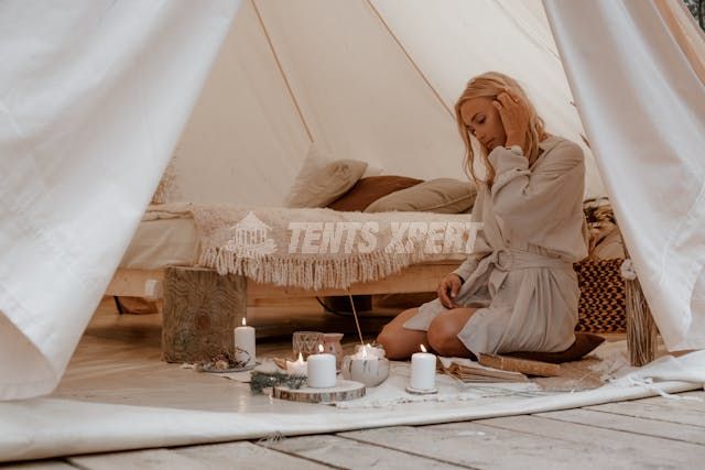  A woman sitting in a tent with lighted candles