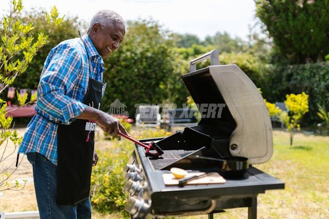 A man using a grill outside